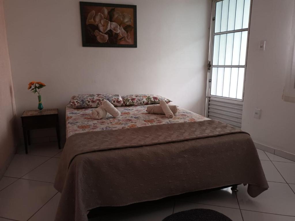 um quarto com uma cama com duas almofadas em Apartamento aconchegante 12 min da praia em Cabo Frio