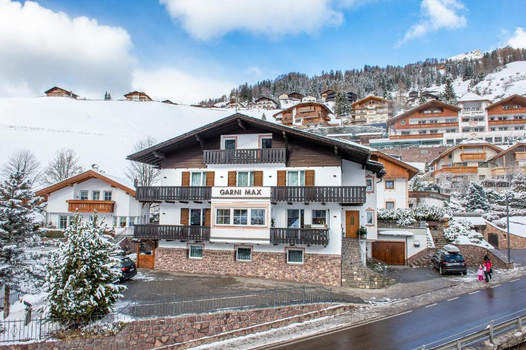 a building in the mountains with snow on the ground at Garni Hotel Max in Santa Cristina in Val Gardena