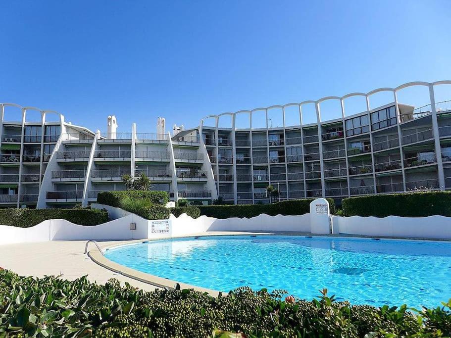 um grande edifício de apartamentos com uma grande piscina em *Les Dunes, 50 m des plages, clim, Netflix,4 pers* em La Grande-Motte