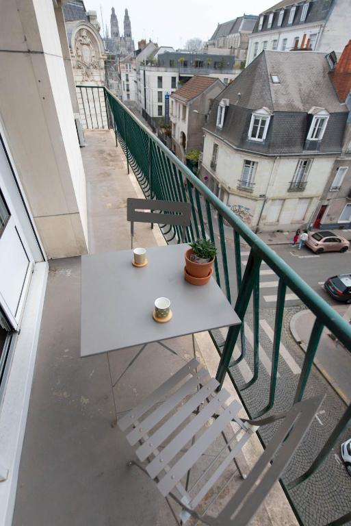 stół na balkonie z dwoma filiżankami kawy w obiekcie Appartement LE JULES FAVRE w Tours
