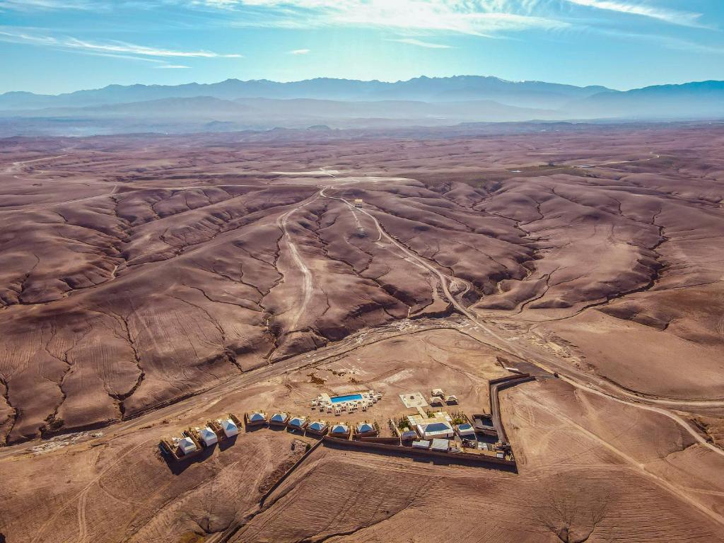 una vista aerea su un campo deserto con una fattoria di Oxygen Lodge Agafay a El Karia