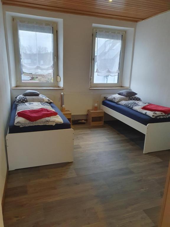 two beds in a room with two windows at Ferienwohnung Linden 87 in Willich