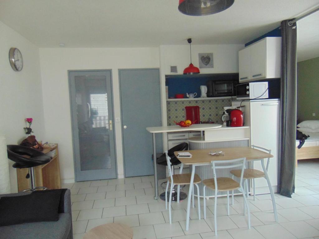 une petite cuisine avec une table et un réfrigérateur dans l'établissement Artémis 17, à Dax