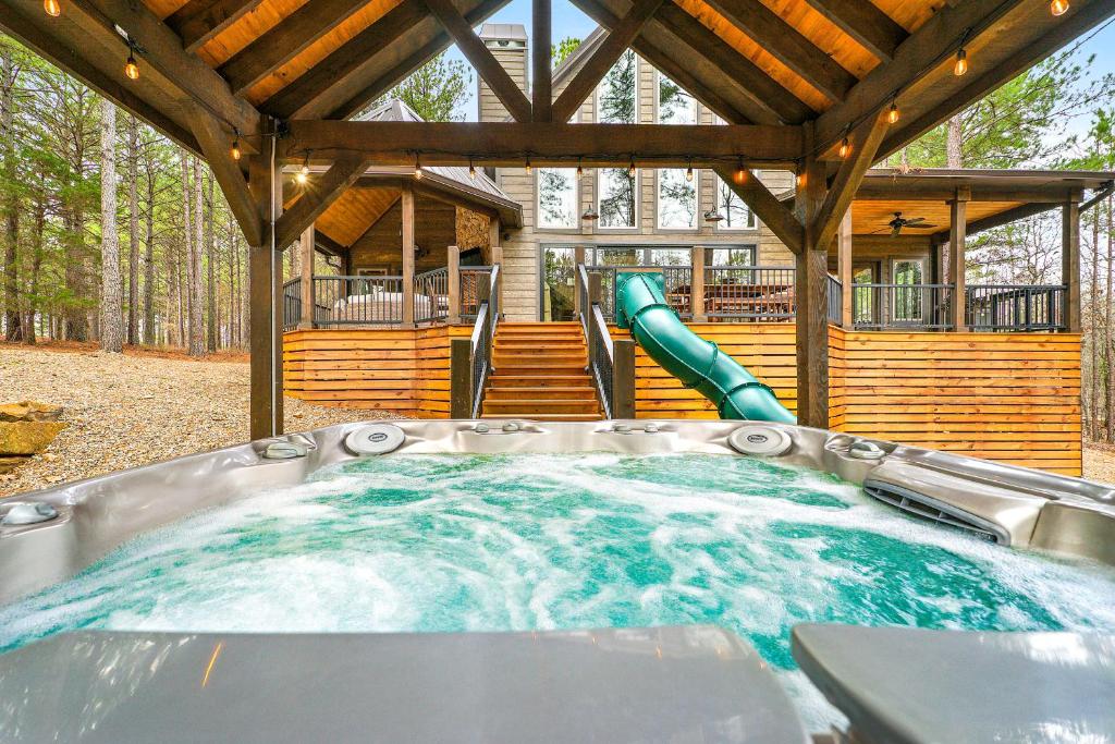 a hot tub in the backyard of a log cabin at Pine Creek Lodge in Broken Bow