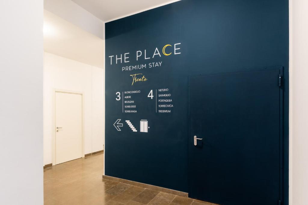 a blue door with the place sign on a wall at The Place - Only Self Check-in - No Reception in Trento
