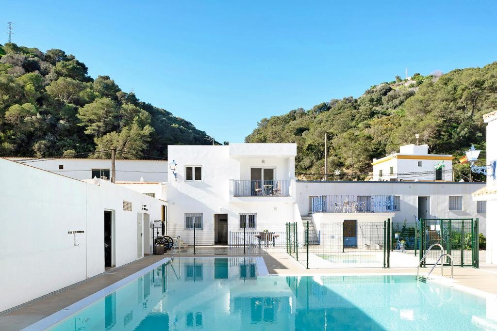 a villa with a swimming pool in front of a building at Casa de 10 Dúplex in Vejer de la Frontera