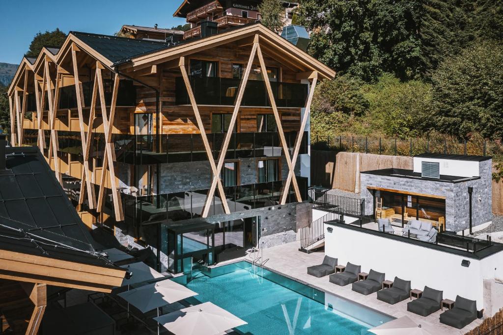 een luchtzicht op een huis met een zwembad bij GLEMM by AvenidA Superior Hotel & Residences in Saalbach Hinterglemm