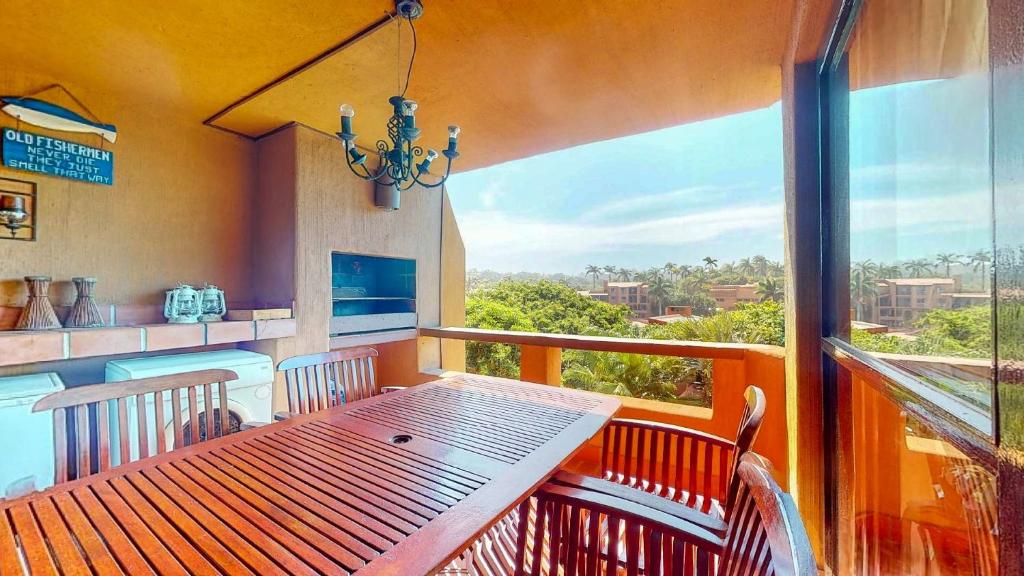 a balcony with a table and a kitchen with a view at San Lameer 3123 by Top Destinations Rentals in Southbroom