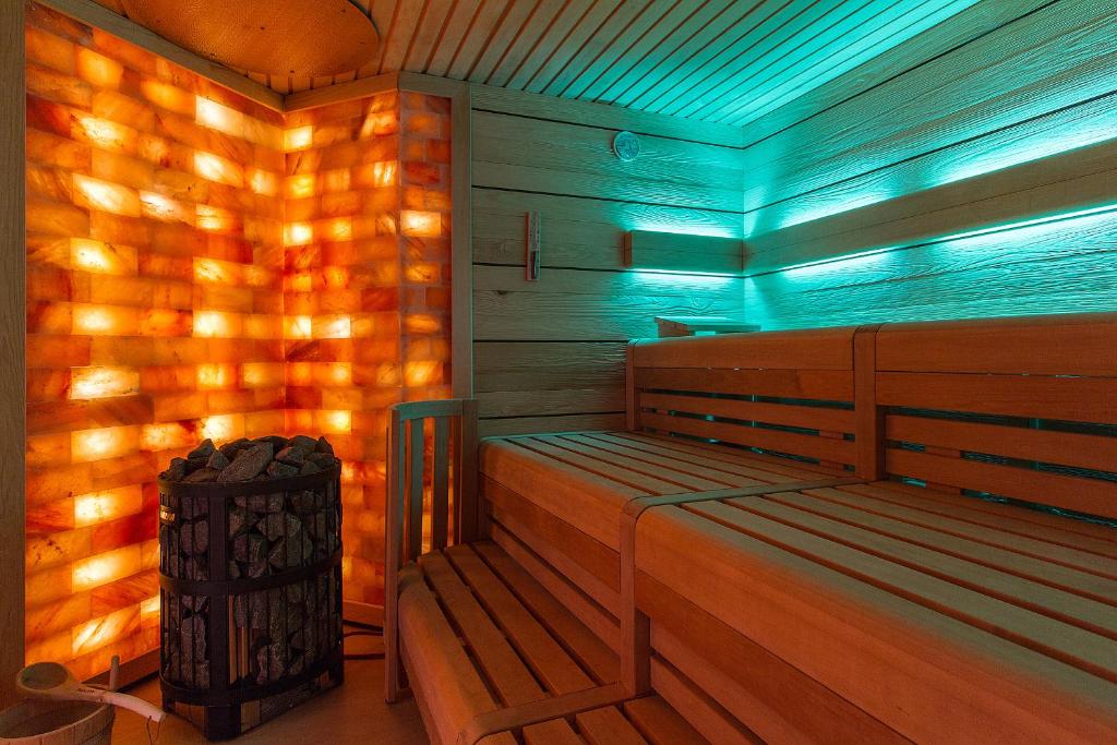 a sauna with a wooden bench and a trash can at HOTEL am STRAND in Kühlungsborn