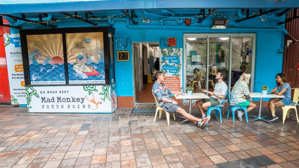 a group of people sitting at tables outside a restaurant at Mad Monkey Potts Point in Sydney