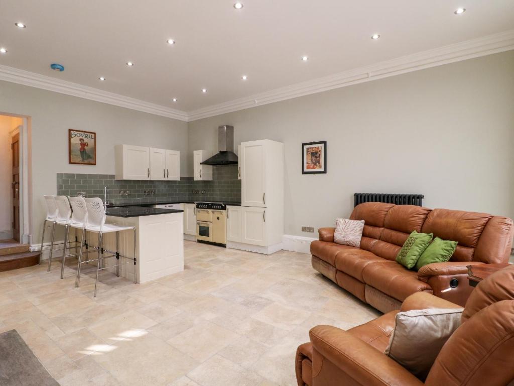 ein großes Wohnzimmer mit Couch und Küche in der Unterkunft Cotton Mill Cottage in Mansfield