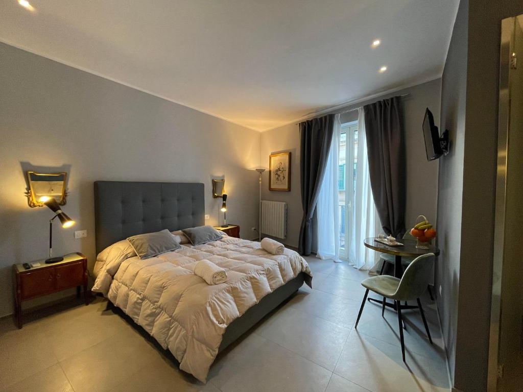 sypialnia z łóżkiem, stołem i krzesłem w obiekcie Dimora San Gregorio Luxury Rooms w mieście Palermo