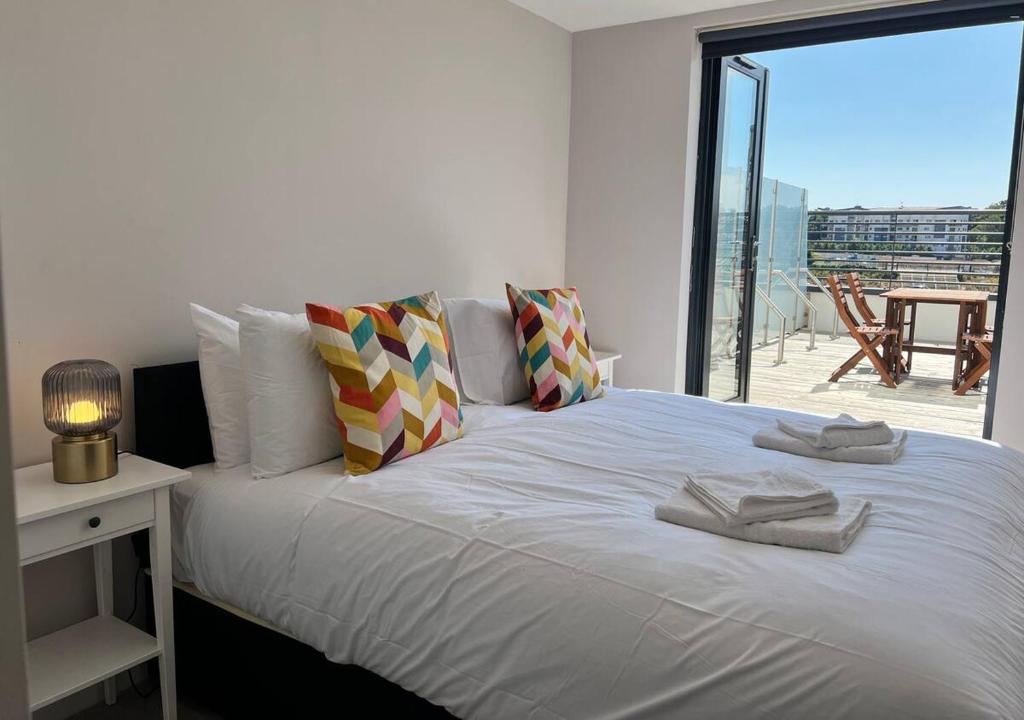 a bedroom with a white bed with a balcony at Margate Seaside Haven With 2 Terraces Sleeps 6 in Kent