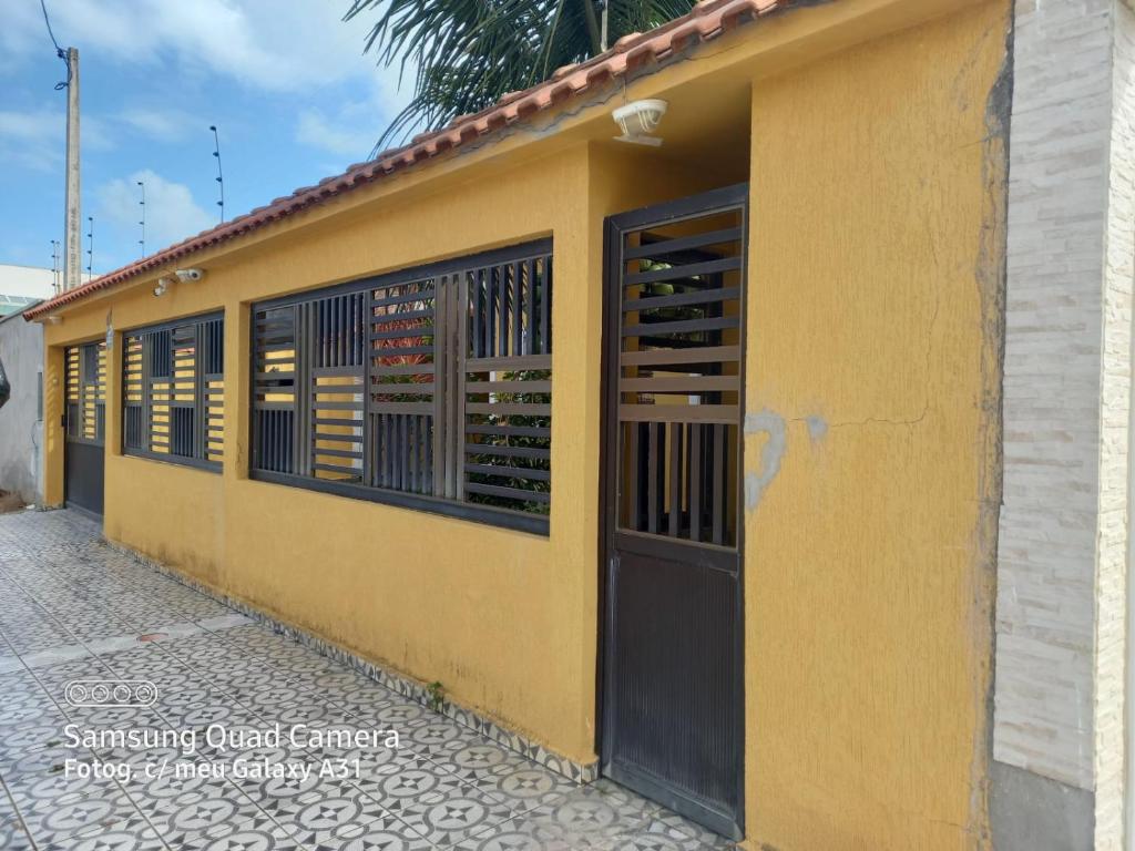 a yellow building with a door and a wine cellar at Casa pé na areia (50 mestros da praia) in Peruíbe