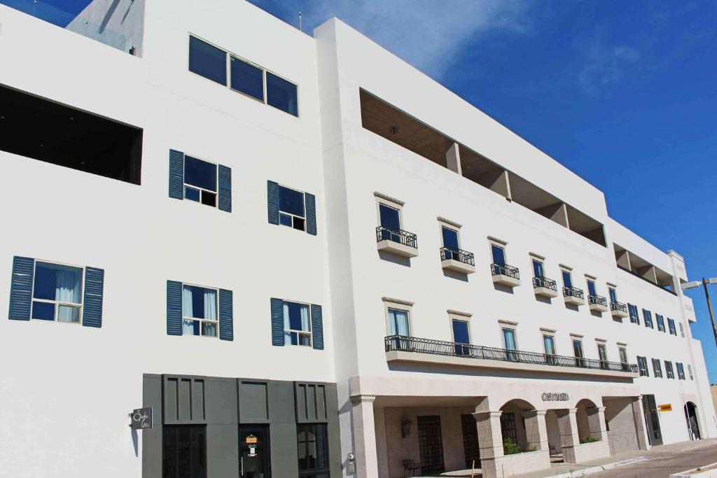 ein weißes Gebäude mit blauen Türen und Fenstern in der Unterkunft Casa Maria Boutique Hotel in San Carlos