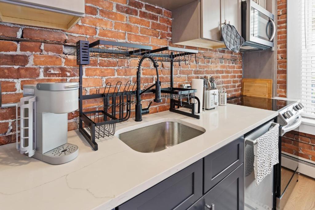 a kitchen with a sink and a brick wall at 5BR Beach Block Orange Loop Steps from Boardwalk in Atlantic City