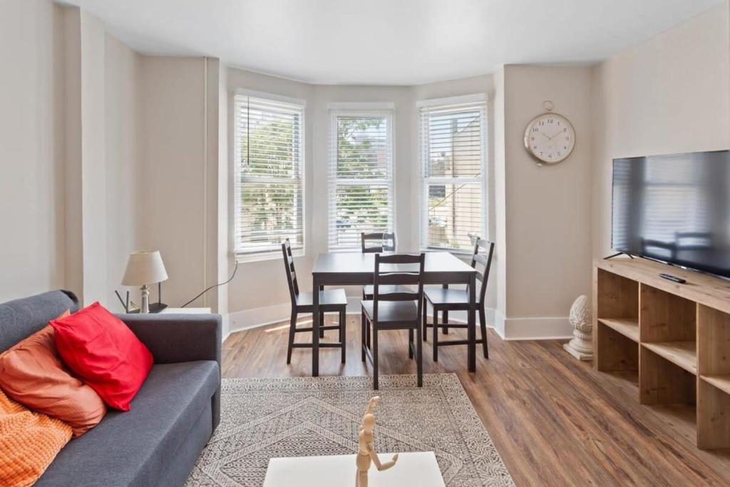 a living room with a couch and a dining room table at 5BR Beach Block Orange Loop Steps from Boardwalk in Atlantic City