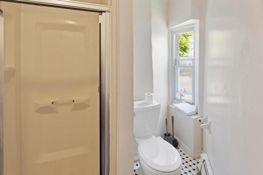 a bathroom with a toilet and a window at 5BR Beach Block Orange Loop Steps from Boardwalk in Atlantic City