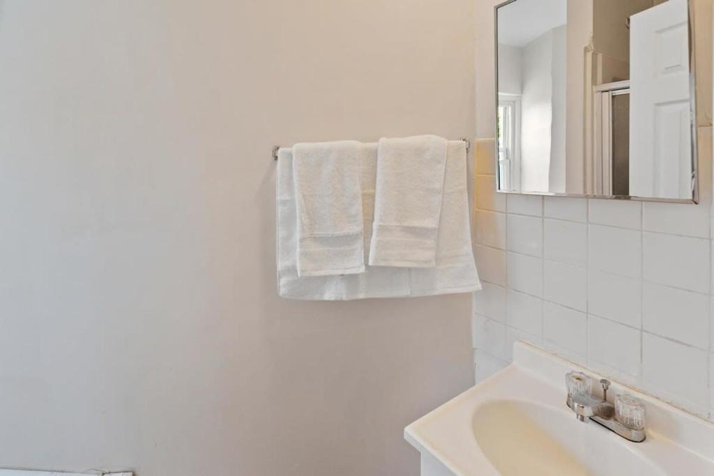 a bathroom with a sink and a mirror and towels at 5BR Beach Block Orange Loop Steps from Boardwalk in Atlantic City
