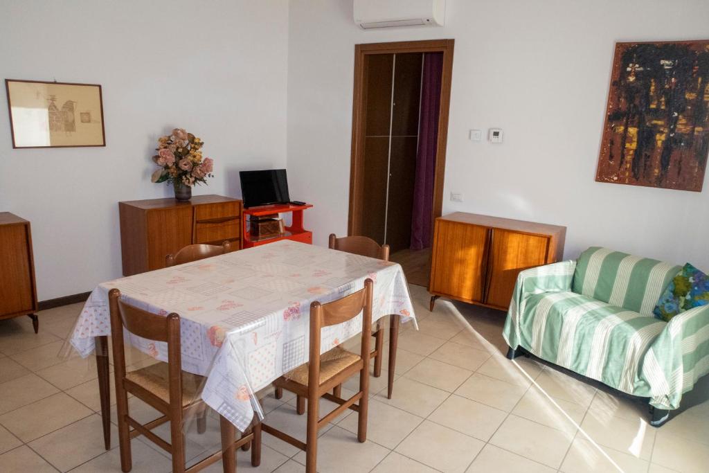 een woonkamer met een tafel en stoelen en een bank bij Bilocale Esperanto in Pianoro