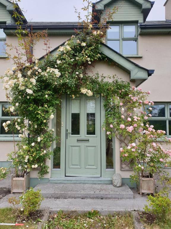 una puerta de entrada de una casa con rosas en The River House en Slane