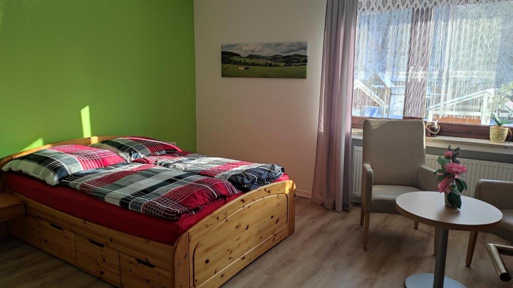 a bedroom with a bed and a table and a window at FeWo Eschert in Waldeck