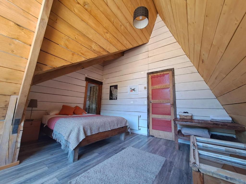 a bedroom with a bed in a wooden attic at Hostal Dos Volcanes in Malalcahuello
