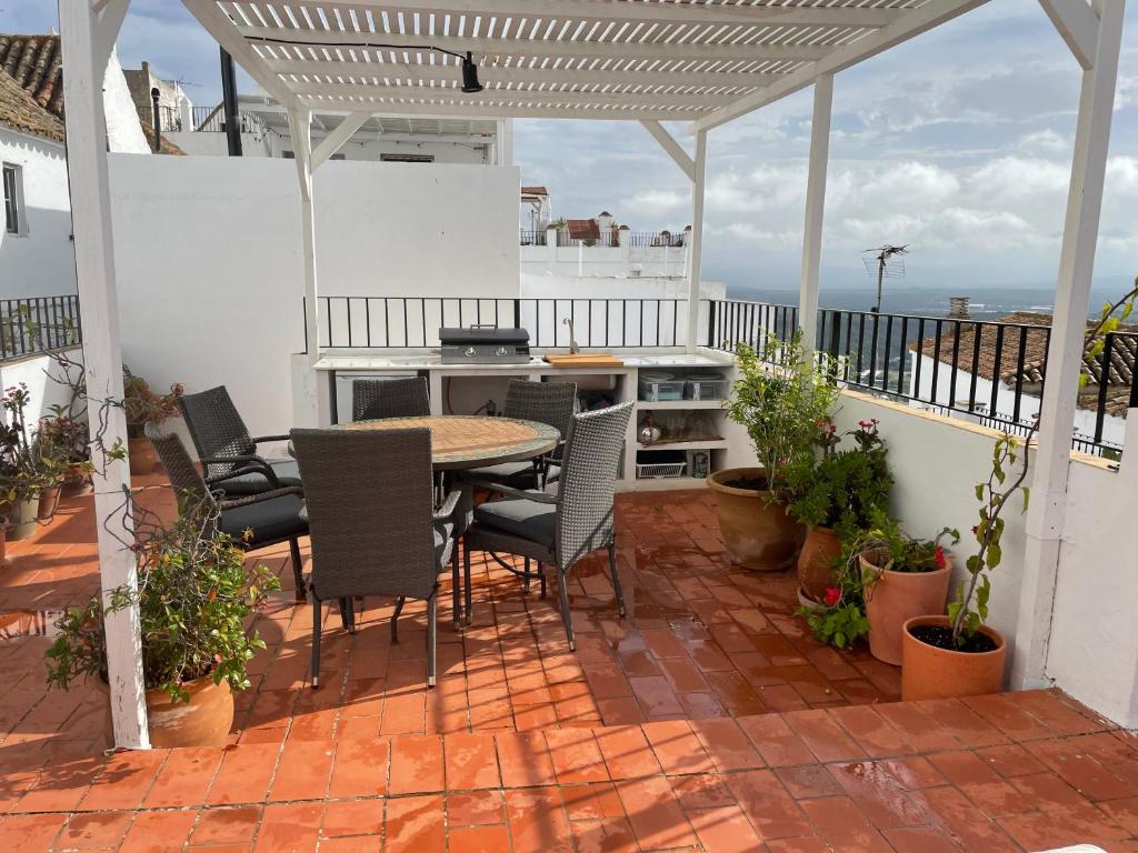 een patio met een tafel en stoelen op een balkon bij Cassa Dulce in Vejer de la Frontera