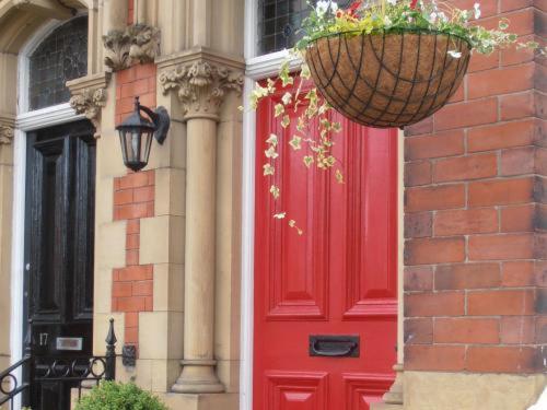 a red door of a building with a basket of flowers at Inglewood in Chorley