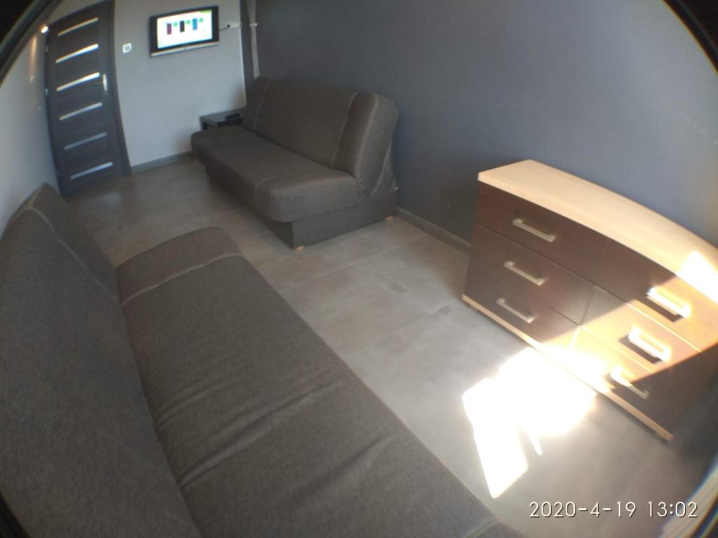 a living room with a couch and a chair at 2120 Przyjaźni 4 - Tanie Pokoje - samodzielne zameldowanie - self check in in Poznań