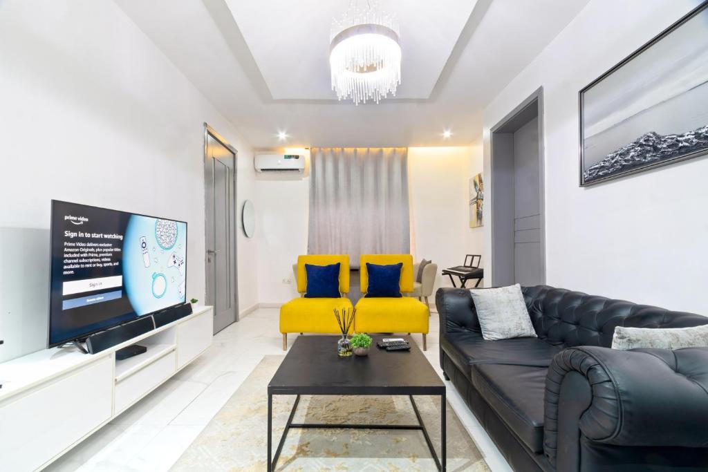 a living room with a couch and two yellow chairs at Exclusive Upscale 1 Bedroom Apartment in Lekki phase 1 in Lagos