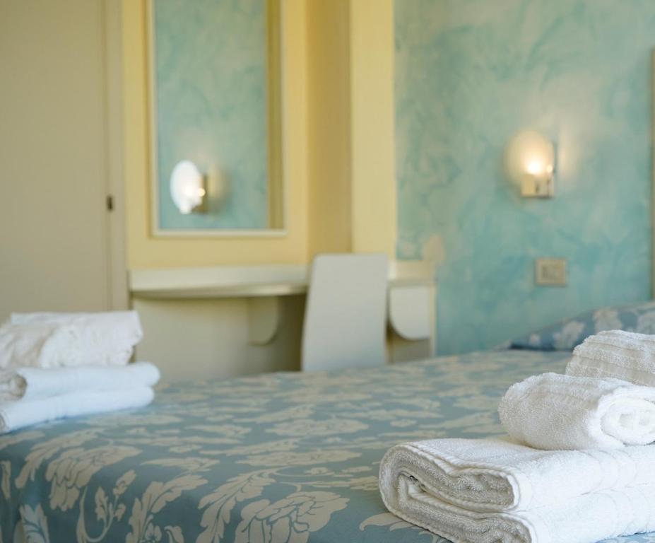 a hotel room with a bed with towels on it at Hotel Embassy in Cesenatico