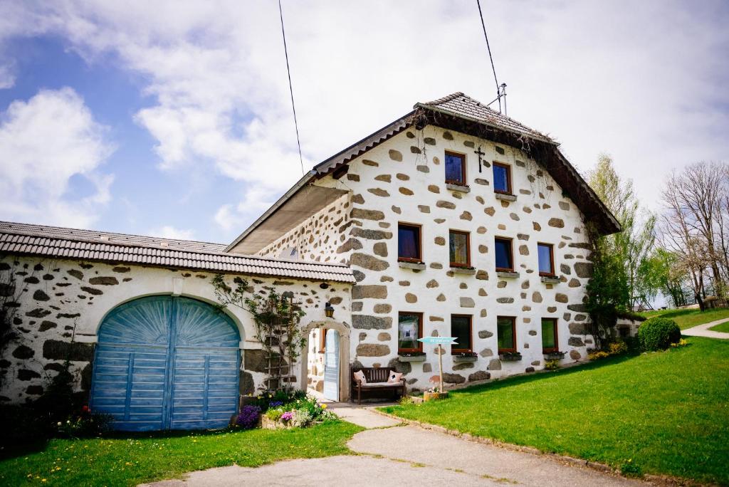 a large stone house with a blue garage at Biohof Abraham - Hofkäserei 