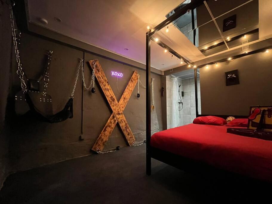 a bedroom with a x sign on the wall at Les 50 nuances de rouge LOVEROOM in Souppes-sur-Loing