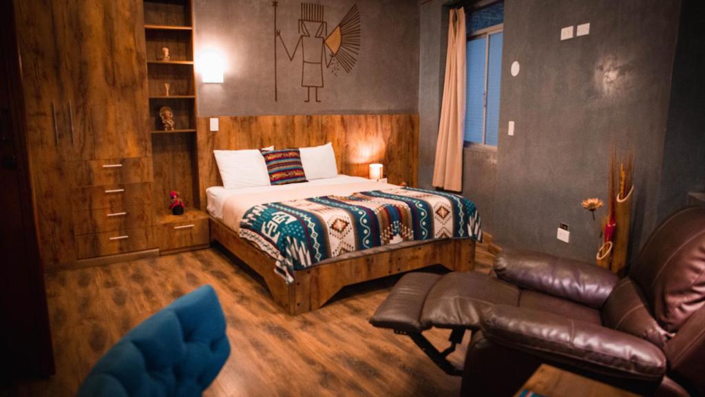 um quarto com uma cama, um sofá e uma cadeira em Chakana Hotel Boutique Centro em Quito