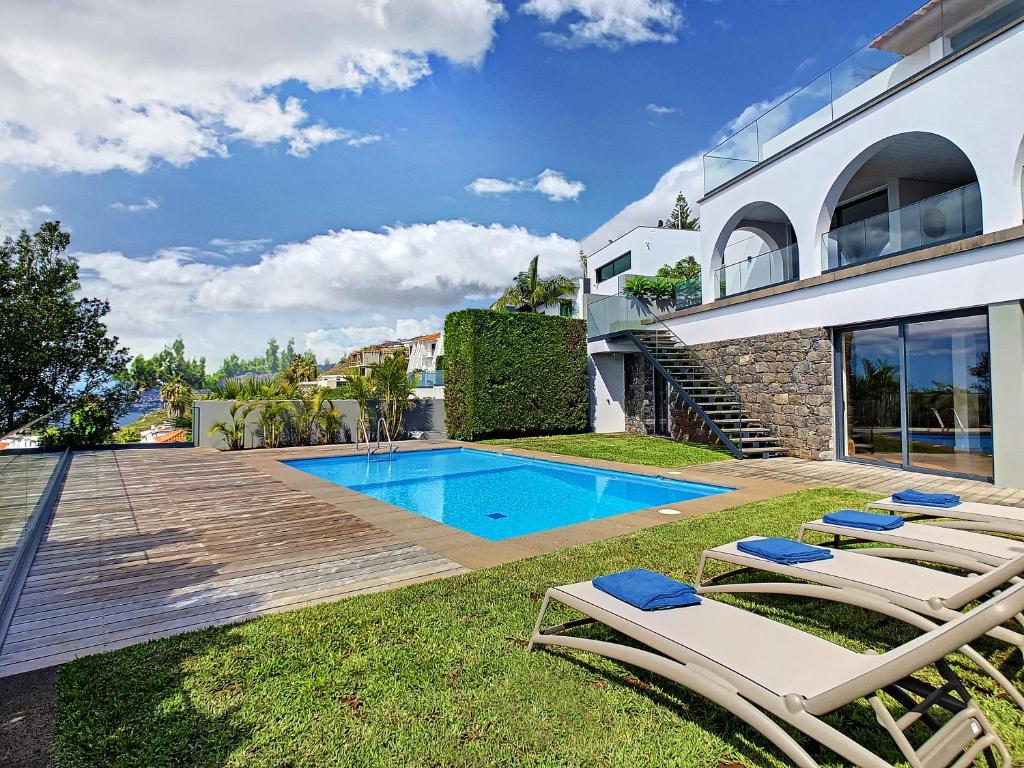 a villa with a swimming pool and two lounge chairs at Unmei by LovelyStay in Caniço