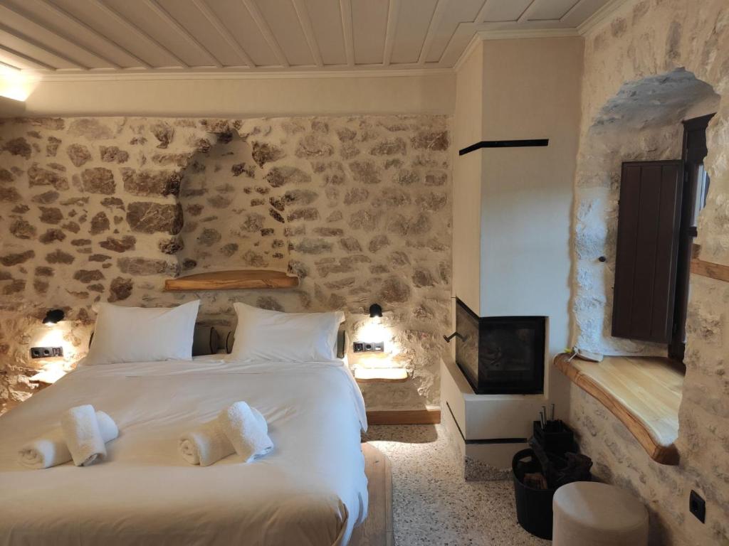 a bedroom with a large bed and a stone wall at Casagli Luxury Suites in Dimitsana
