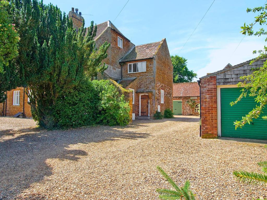 a house with a green garage door on a gravel driveway at Church View in Hunstanton