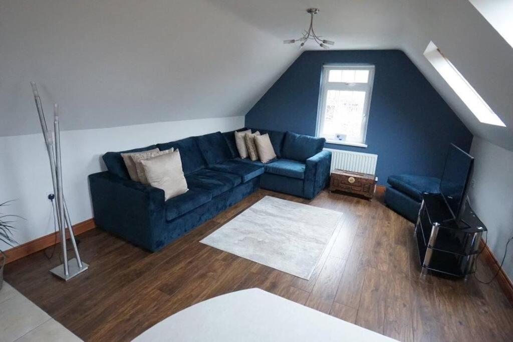a living room with a blue couch and a chair at Belfast Loft in Belfast