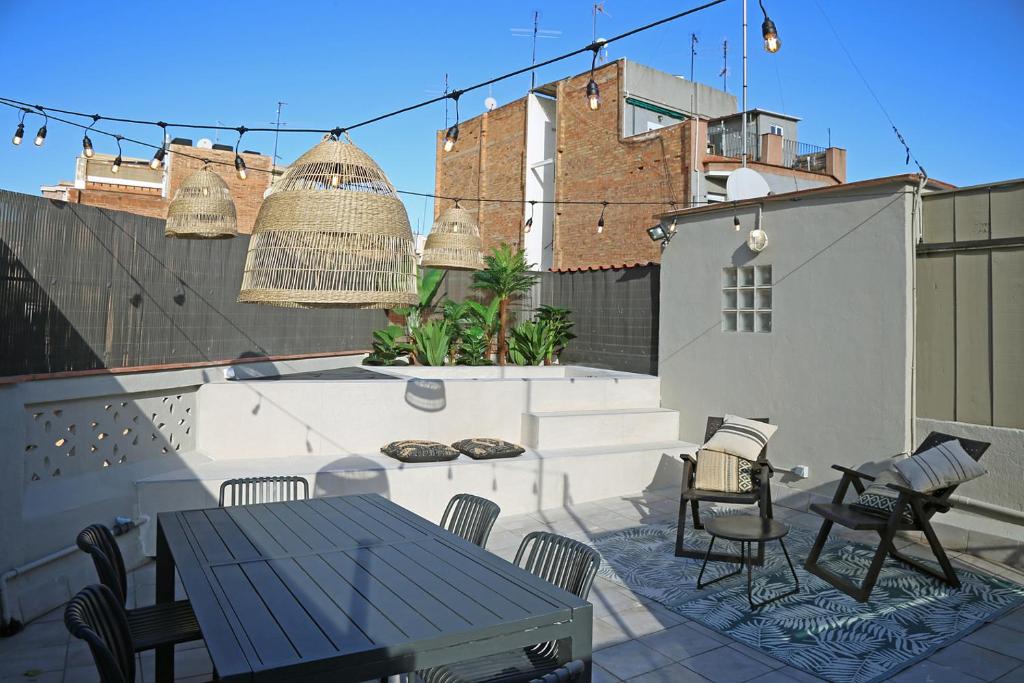 un patio con mesa, sillas y jaula para aves en Fridays Flats Onix House, en Barcelona