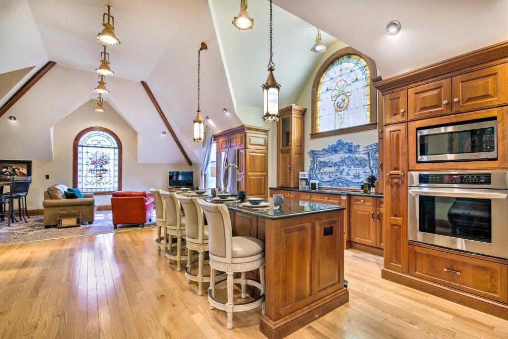 a kitchen with wooden cabinets and a bar with stools at Historic Guest House on Castle Kimble Estate! in Manhattan