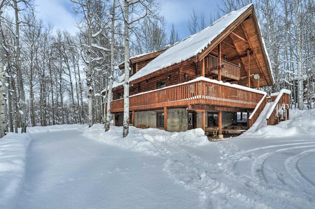 a log cabin in the snow with a lot of snow at Star Valley Ranch Cabin Getaway Hot Tub! in Thayne