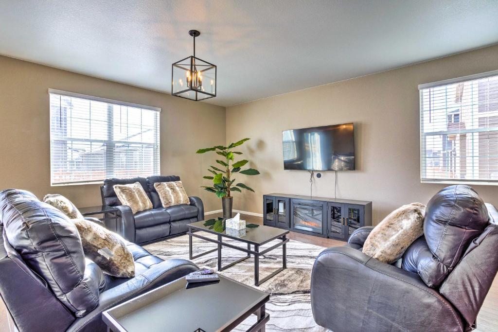 a living room with leather furniture and a tv at Spacious Aurora House with Yard about 10 Mi to DIA! in Aurora