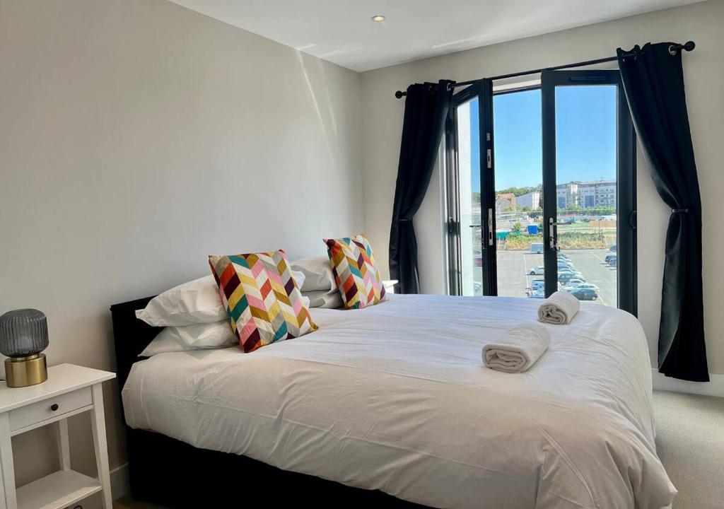 a bedroom with a large white bed with a window at Margate Main Sands Sea views Central Location Sleeps 4 in Kent