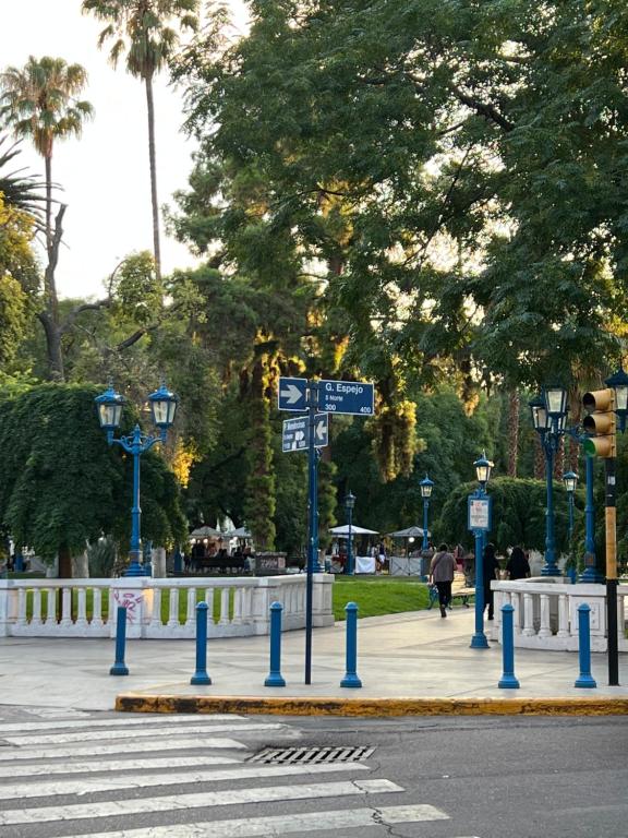 una calle con postes azules y letreros en una acera en Plaza Independencia 2023 en Mendoza