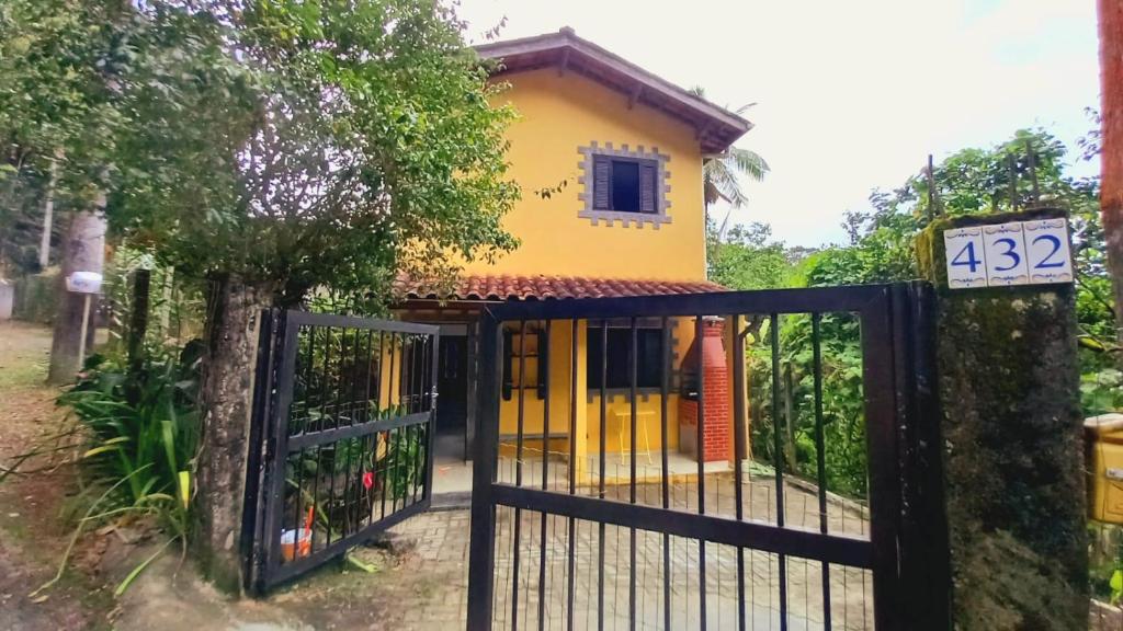 a house with a gate in front of it at Casas Jacatirão in Ubatuba