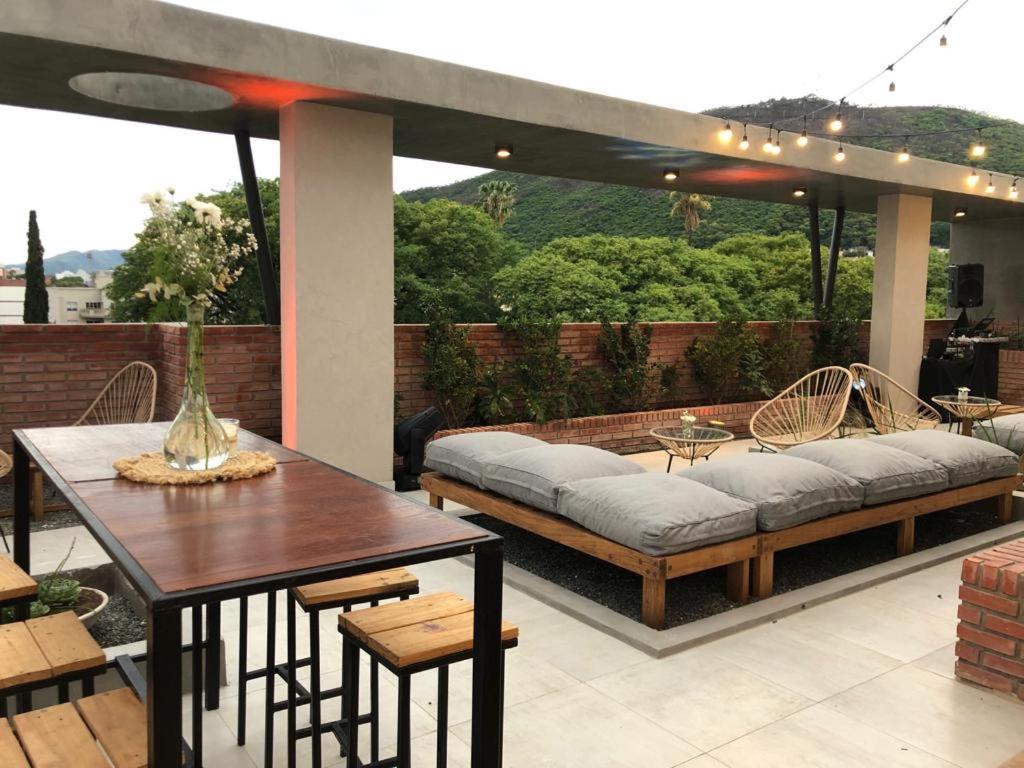 eine Terrasse mit einem Sofa, einem Tisch und Stühlen in der Unterkunft Usina Studio FMA-Coliving in Salta