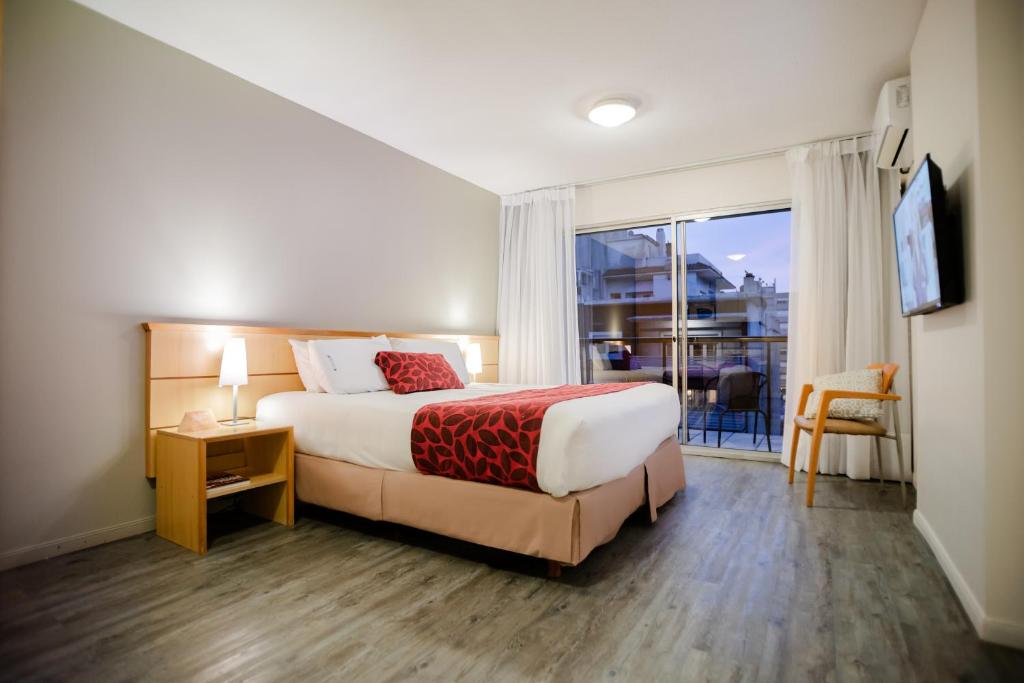 a hotel room with a bed and a large window at Punta Trouville Hotel in Montevideo