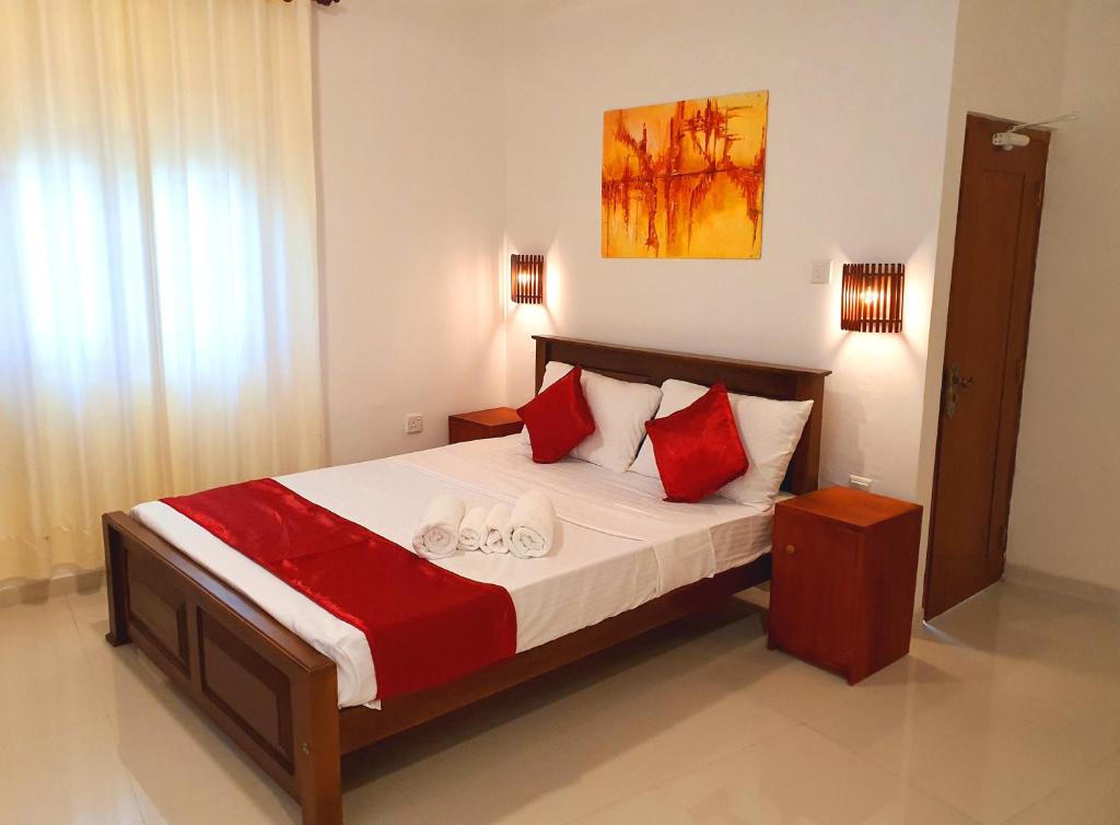 a bedroom with a bed with red and white pillows at Allen Lilly Ahangama in Ahangama