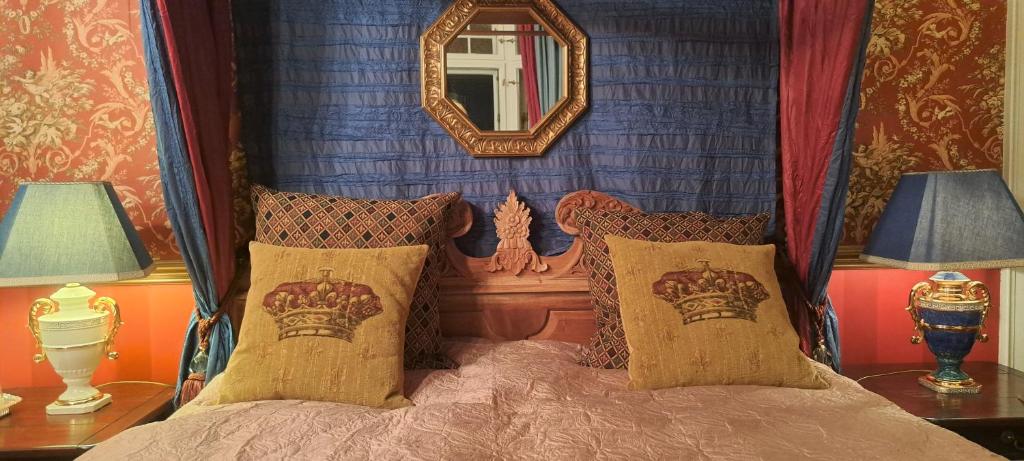 ein Schlafzimmer mit einem Bett mit einem Spiegel und 2 Lampen in der Unterkunft Villa am Stechlin in Neuglobsow